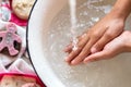 ChildÃ¢â¬â¢s hands under white bowl with water upon water stream Royalty Free Stock Photo