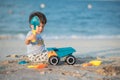 Child\'s Joyful Beach Adventure. Baby boy playing on the beach with a toy truck Royalty Free Stock Photo