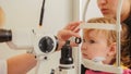 Child`s ophthalmology - doctor optometrist checks eyesight at little girl Royalty Free Stock Photo