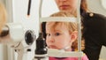 Child`s optometry - little girl hecks eyesight in eye ophthalmological clinic Royalty Free Stock Photo