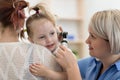 Child`s otolaryngologist doing ear examination of little girl