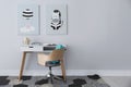 Child`s room interior with desk and cute posters on light wall. Space for text Royalty Free Stock Photo