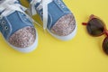 Child`s textile lace sneakers. girls shoes on yellow background.Fashion kid`s footwear.Smart casual fashionable denim Royalty Free Stock Photo