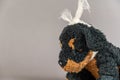 A child`s toy with a bandaged head. A black stuffed dog against a gray background. Childhood trauma concept. Mental health.