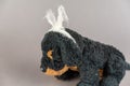 A child`s toy with a bandaged head. A black stuffed dog against a gray background. Childhood trauma concept. Mental health.