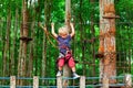 Child in safety harness pass obstacle in adventure rope park
