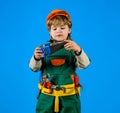 Child in safety helmet and toolbelt with saw. Work with tools. Boy in builder uniform with tool for repair. Little Royalty Free Stock Photo