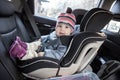 Child safety seat with smiling infant child is on back seat of car, kid eight month old Royalty Free Stock Photo