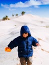 child in the Sahara desert plays with the sand of the dunes, tourist on vacation