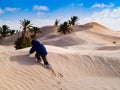child in the Sahara desert plays with the sand of the dunes, tourist on vacation