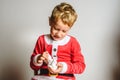 Child in Santa costume playing with shaving cream to have fun at Christmas