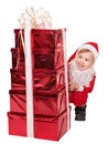 Child in santa hat by stack gift box. Royalty Free Stock Photo