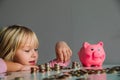 Child saving money, cute girl put coins into piggy bank Royalty Free Stock Photo