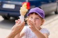 Child, school age girl receiving a large tasty ice cream cone. Sugar, sweets, children and ice-cream simple concept, outdoors