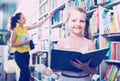 Child in school age looking in open chosen book