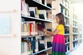 Child in school library. Kids reading books