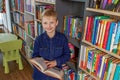 Child schoolboy reading book in library or bookstore. Concept of back to school and education Royalty Free Stock Photo