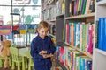 Child schoolboy reading book in library or bookstore. Concept of back to school and education Royalty Free Stock Photo