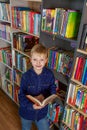 Child schoolboy reading book in library or bookstore. Concept of back to school and education Royalty Free Stock Photo