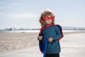 Child on scooter in park. Kids learn to skate roller board. Power kids, super hero child in a superhero raincoat. Royalty Free Stock Photo