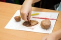 Child sculpts from clay.