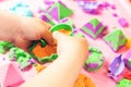 The child sculpts figures from multi-colored kinetic sand, developing fine motor skills of hands