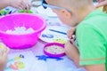 Child sculpts figures from plasticine. development center. help children with disabilities. A pretty girl of three years old sits Royalty Free Stock Photo