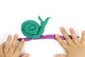 A child sculpts a snail from modeling clay, plasticine Royalty Free Stock Photo