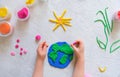 Child sculpturing plasticine planet for earth day. Protection of environment, Royalty Free Stock Photo