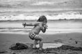 Child is on a sea holiday. Cute muddy baby boy plays with wet sand Royalty Free Stock Photo