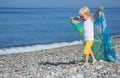 Child with shawl goes on pebble beach