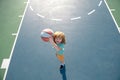 Child shooting Basketball ball and playing basketball, lower view wide angle. Kids sport activity.