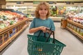 Child with shopping basket. Kid in a food store or a supermarket. Little kid going shopping. Healthy food for kids. Royalty Free Stock Photo
