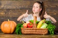 Child show thumbs up celebrate harvest holiday vegetables basket. Kid farmer with harvest wooden background. Harvest Royalty Free Stock Photo