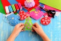 Child shows Christmas crafts. Felt fur-tree, mitten, heart, ball decor Royalty Free Stock Photo