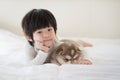 Child and siberian husky puppy lying on white bed