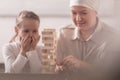 child with sick grandmother in kerchief playing with wooden Royalty Free Stock Photo