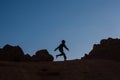 Child silhouette running over the rocks in the desert at sunset Royalty Free Stock Photo