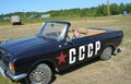 A child sits in a black car Moskvich convertible with the inscription `USSR` at an exhibition of vintage cars Royalty Free Stock Photo