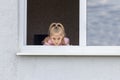 The child sits at low tide in the window in his hands a toy. Look at us. Dangerous situation Royalty Free Stock Photo