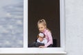 The child sits at low tide in the window in his hands a toy. Look at us. Dangerous situation Royalty Free Stock Photo