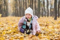 A child sitting in autumn leaves