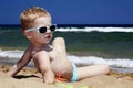 Child sitting on the beach in sand. little boy near the sea Royalty Free Stock Photo