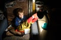 Child Sitting On a Chair In a Dark Room In Front Of The Lamp Royalty Free Stock Photo