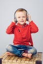 Child sitting with crossed legs and listening to music.