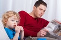 Child sitting with dad reading newspaper Royalty Free Stock Photo