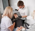 Dentist and assistant examining little girl teeth in dental office. Royalty Free Stock Photo