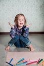 Child sitting on the floor near crayons and paper. Little girl drawing, painting. Creativity concept. WOW. oops