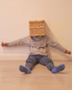 Back to school. Child sitting on the floor in pajamas hiding under a box to avoid going to school Royalty Free Stock Photo