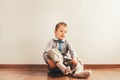 Child sitting on the floor putting on his socks with an expression of effort, concept of autonomy Royalty Free Stock Photo